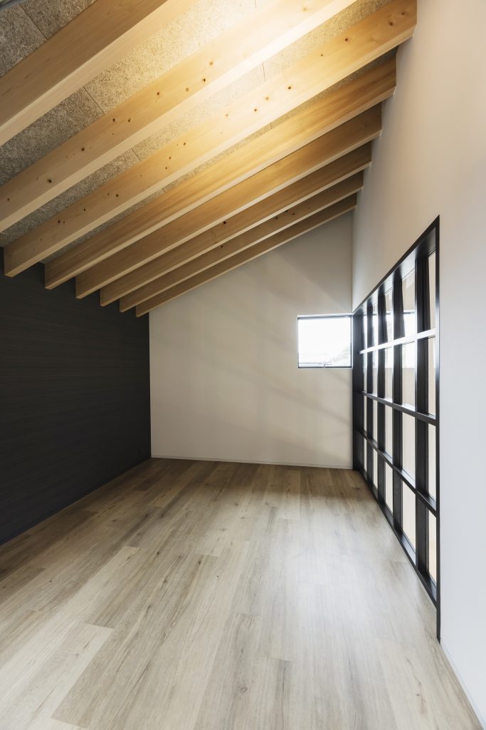 Children's bedroom at Sunset Villa with exposed timber rafter ceiling, timber floor and full-height steel-framed glazed partition wall