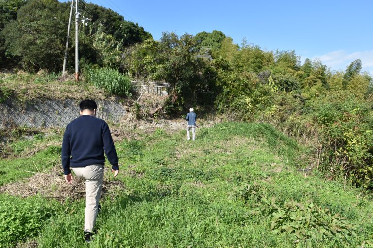 Builder and architect conducting pre-design site inspection of overgrown land parcel at Vista Wellmina Villa, Awajishima