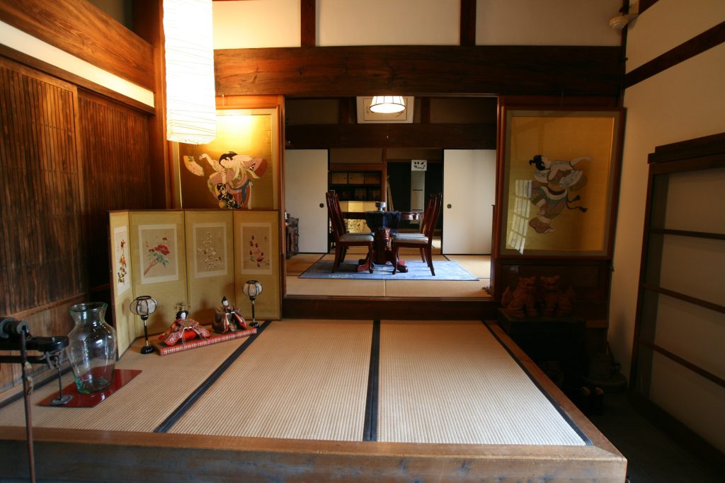Interior of a high-grade 70-year-old Japanese kominka reflecting wealthy original ownership — layered tatami rooms, folding screens, and quality traditional fittings