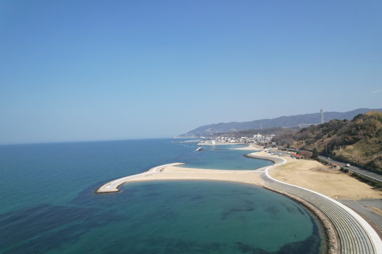 Aerial view of Awaji Island coastline showing sandy beach, seawall, and Seto Inland Sea, Hyogo Prefecture Japan