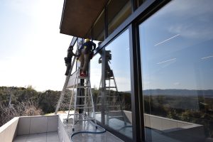 Japanese post-construction cleaning team washing exterior glass of architect-designed villa in Japan